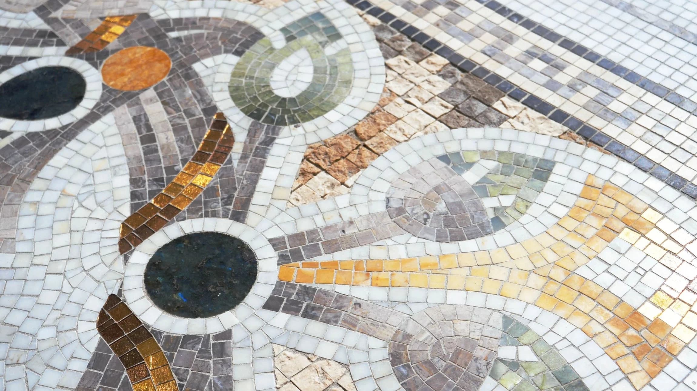 Artisan hand-cutting mosaic tesserae for bespoke luxury surface