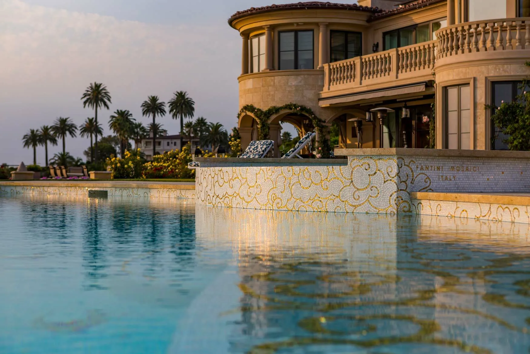 Mediterranean villa at sunset with a gold and white mosaic swimming pool wall in Los Angeles